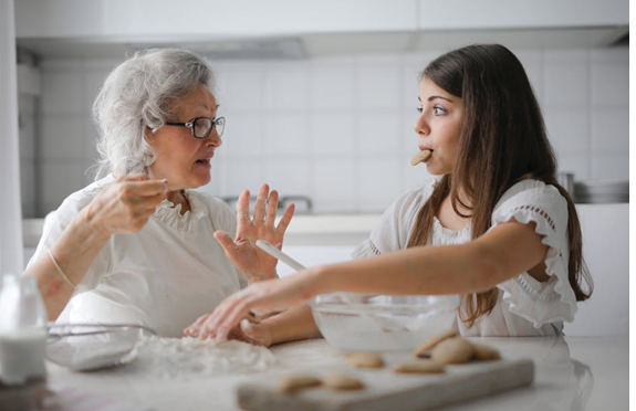 A grandmother and her granddaughter spend time and bond while baking in the kitchen.