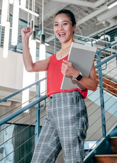 A woman looks happy, active, and healthy while at work, showing off her toned arms.